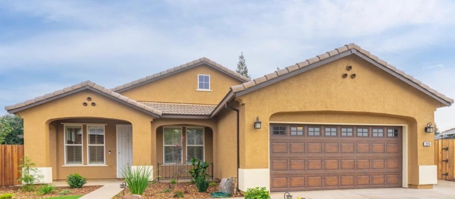 House exterior in Lincoln, California before repainting, in tan stucco with a wood garage door